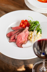 プレートに乗った肉料理と、付け合わせの野菜と赤ワイン