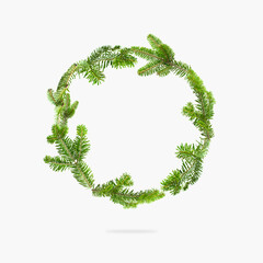 Fresh green spruce branches in the form of circle on light background. Fir tree frame, Christmas or New Year decoration. Natural spruce, branches with needles. Winter, holiday card creative background