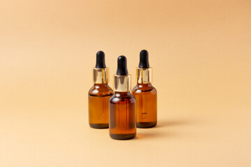 An amber bottle for essential oils and cosmetics stands next to the stone. Glass bottle on a pink...