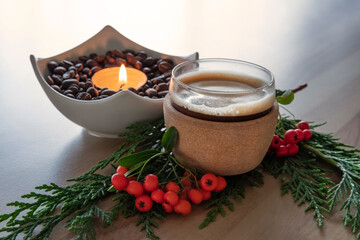 Coffee cup with fir branches and red vegetable balls