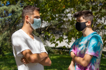 young people or students with masks talking in the street or park