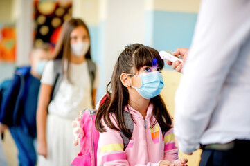Teacher doing temperature check on school children 