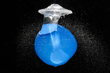 blauer, mit Wasser gefüllter Ballon explodiert