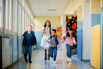Group of children running through the hall of a school