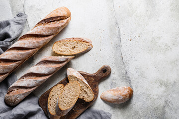 Top view of two brown baguettes on a concrete background.