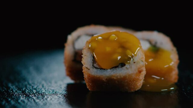 Roles sushi girando suavemente con salsa cayendo encima. HD