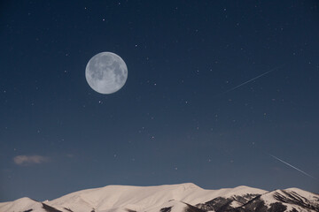 Beautiful full moon on the  starry sky. over the mountains.