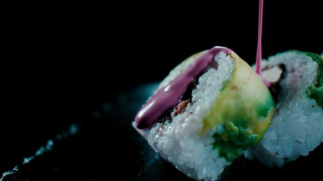 Slide en Roles de Sushi con palta cayendo suavemente salva de olvio.  240 FPS HD