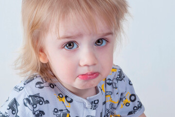 Offended kid with insulted expression face, purses his lips in discontent (concept emotions)