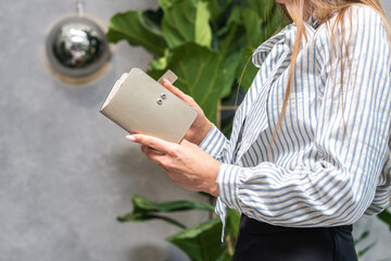 Girl holding a silver wallet on a green flower background
