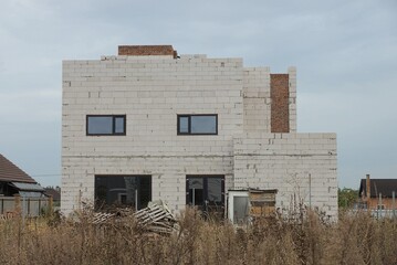 Fototapeta na wymiar a large unfinished private house made of white bricks 