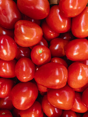 Tomatoes in the hypermarket. Bright red fresh tomatoes. Vertical image.