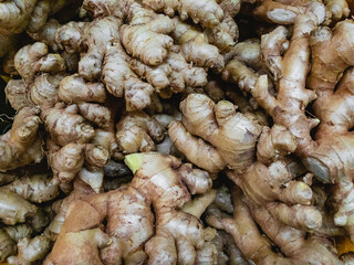 Raw ginger for sale lies in the supermarket. Close-up view.