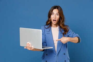 Shocked amazed young brunette woman 20s wearing basic jacket standing pointing index finger working...