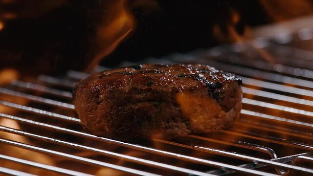 Close Up de carne de hamburguesa en grill con fuego. Cocinando carne de hamburguesa en grill. 240 fps HD