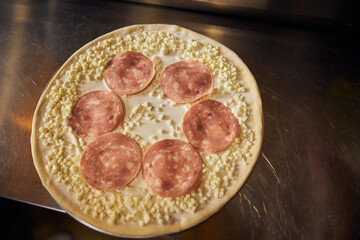 Pizza being prepared for baking in cafe
