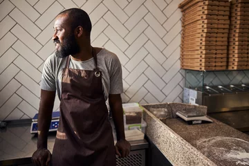Plexiglas foto achterwand Cheerful young male baker working in pizzeria © Viacheslav Yakobchuk