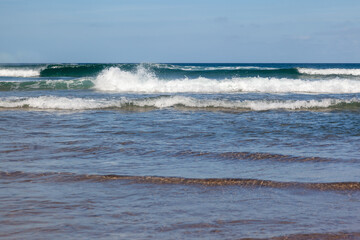 Waves in the ocean on the beach, blue sky