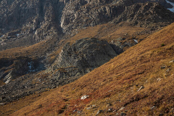rocky mountain landscape with steep, grassy, hill