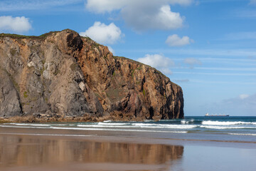 Cliffs and sea rock on a beach, blue sky