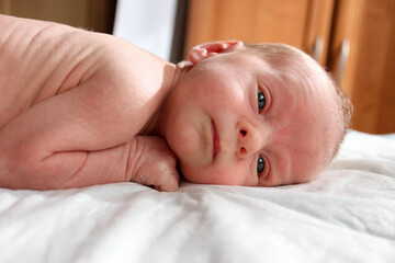 cute newborn child infant with serious face ready to sleep close up