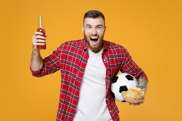 Crazy young man football fan in red shirt cheer up support favorite team with soccer ball bottle of...