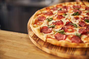 Delicious pepperoni pizza on round wooden board