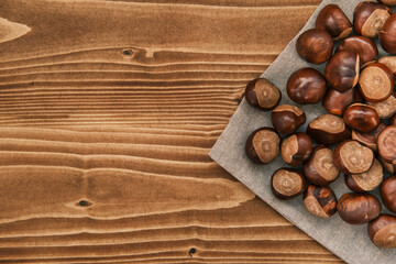 Vertical shot of chestnut on the linen cloth on a wooden table 