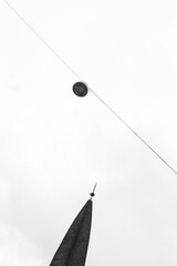 High key image of a street lamp and a tower in black and white