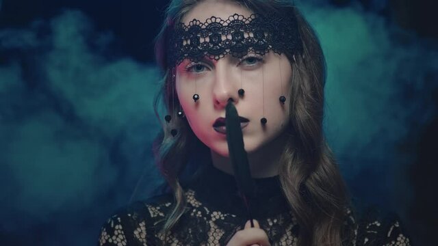 Mystical female in black attire looking at the camera, halloween feast of all saints, portrait of a beautiful young woman.