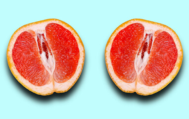 Two halves of grapefruit with shadow isolated on a light blue background.