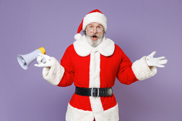 Fototapeta na wymiar Shocked gray-haired Santa Claus man in Christmas hat red suit coat white gloves glasses hold megaphone spreading hands isolated on violet background. Happy New Year celebration merry holiday concept.