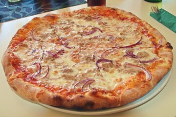 Primer plano de una deliciosa pizza de atún y cebolla. Pizza lista para comer servida en un...