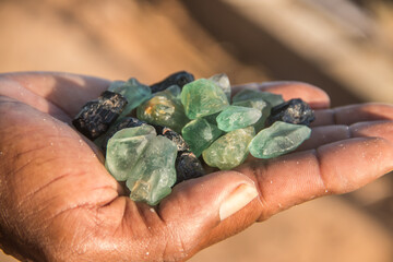 Smuggler showing smuggled precious and semi precious stones excavated in illegal mine, Mozambique