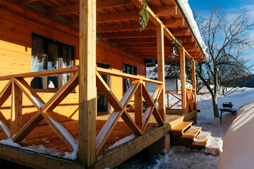 Wooden veranda of a private house in winter. Beautiful light on the outdoor veranda.