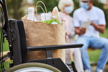 Paper bag with grocery purchases on the wheelchair