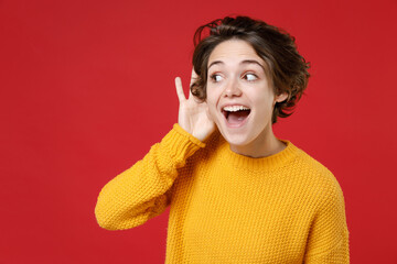 Excited curious young brunette woman 20s wearing casual yellow sweater standing try to hear you...