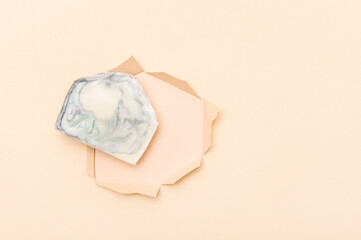 Hand made soap bar in paper cut hole, top view. Space for text. Zero waste concept