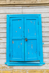locked blue window on an old wooden house