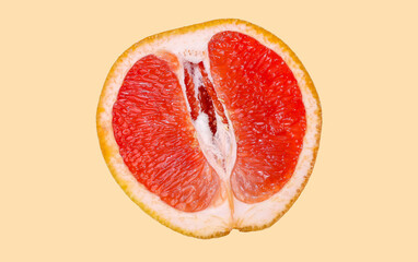 Cut half of a grapefruit on a light beige background.
