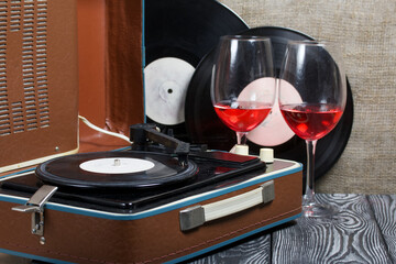 Obraz premium Old turntable. Nearby are two glasses of alcohol. Retro party equipment.
