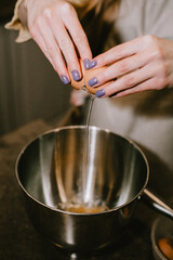 Break an egg into a saucepan. A girl breaks eggs in a bowl to make pastries. The process of baking with your own hands.