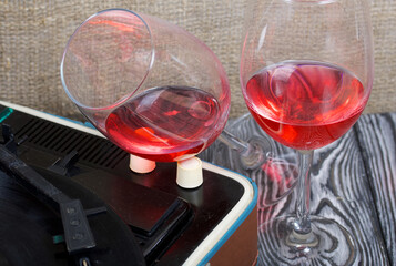 Old turntable. Nearby are two glasses of alcohol. Retro party equipment.