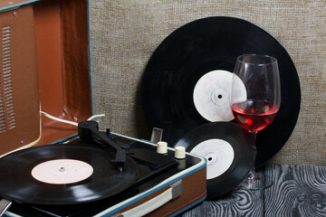 Old turntable. Nearby are two glasses of alcohol. Retro party equipment.