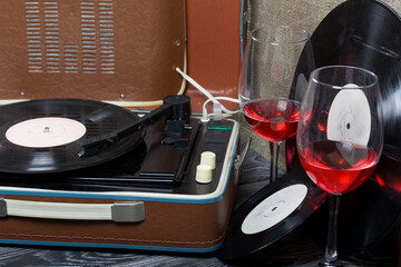 Old turntable. Nearby are two glasses of alcohol. Retro party equipment.