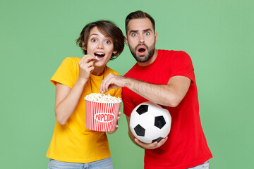 Shocked amazed couple friends sport family woman man football fans in t-shirts cheer up support...