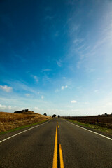 青空の下まっすぐに続くアスファルトの道