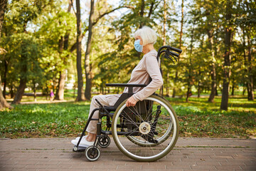 Retired lady in a wheelchair alone in the park
