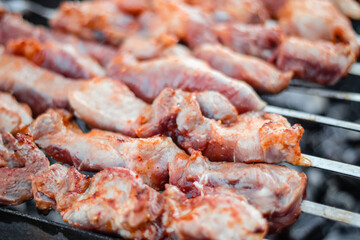 Close up of pieces of pork on skewers fried on the grill.