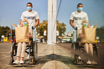 Volunteer and his elderly patient reflecting in shopping centre window